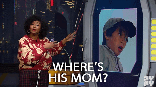 a woman is standing in front of a screen that says " where 's his mom "