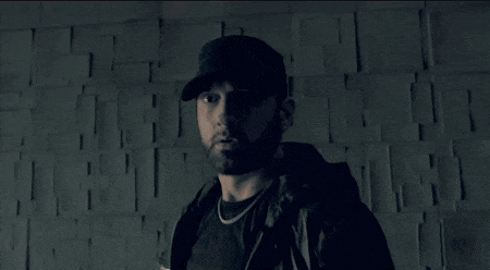 a man with a beard wearing a hat is pointing his finger at the camera