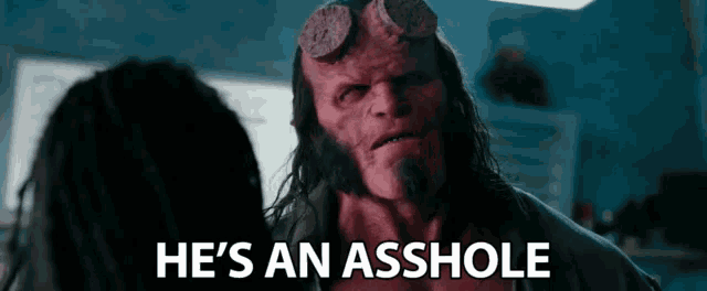 a man with horns is talking to another man with the words he 's an asshole below him