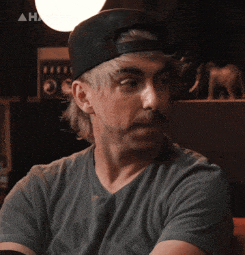 a man wearing a hat and a t-shirt that says ' nm ' on it