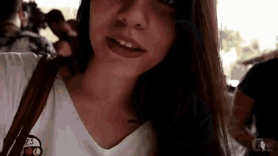 a close up of a woman 's face with a white shirt on and a brown purse .