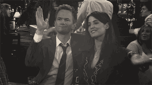 a man in a suit and tie is sitting next to a woman in a crowded bar