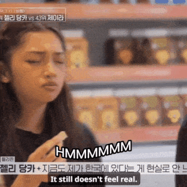 a woman is holding a piece of food and says hmmmmmm