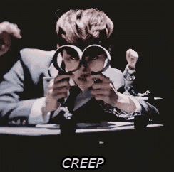 a man in a suit is looking through a magnifying glass with the word creep written on the bottom .