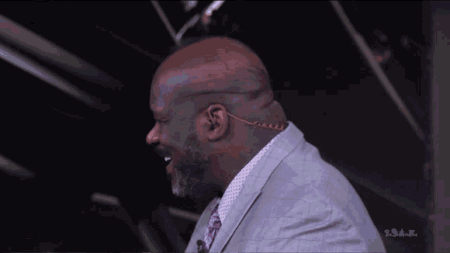 a man in a suit and tie is smiling in front of a sign that says ' smackdown ' on it