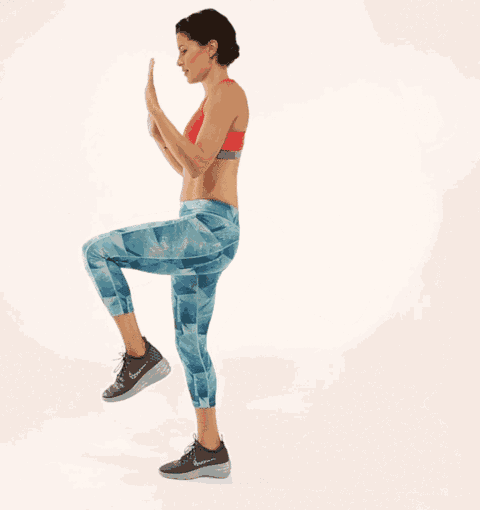 a woman in a red sports bra and blue leggings is doing a workout