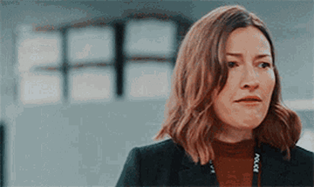 a woman wearing a black jacket and a brown sweater with the word police on it