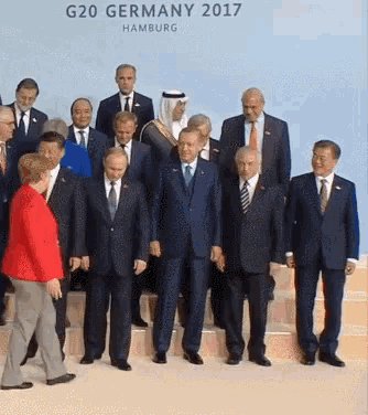 a group of men standing in front of a sign that says " g20 germany 2017 "