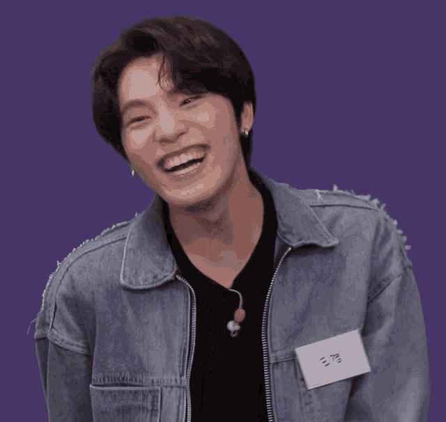 a young man wearing a denim jacket and a name tag that says ' a.v. ' on it