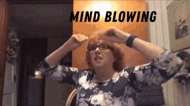 a woman with red hair and glasses holds her hands to her head with the words mind blowing above her