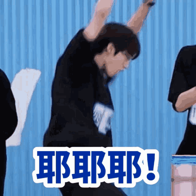 a man in a black shirt is dancing in front of a sign that says ' eeeeee ! '