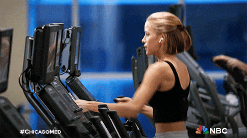 a woman is riding an elliptical in a gym with a nbc logo in the corner