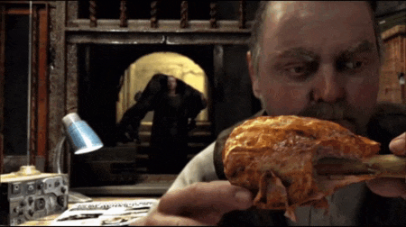 a man is eating a large piece of meat in front of a newspaper that says ' apocalypse '