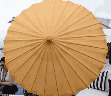 a large yellow umbrella is sitting on a patio