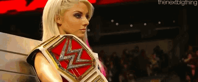 a female wrestler is holding a wrestling championship belt with the letter z on it