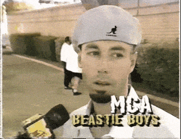 a man wearing a hat with a kangaroo on it is being interviewed by the beastie boys on a video