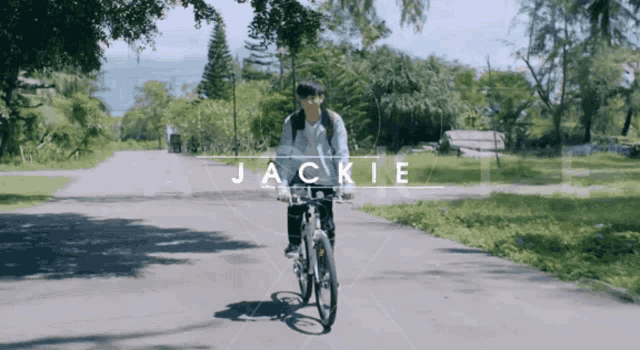 a person riding a bike on a road with the word jackie on the bottom