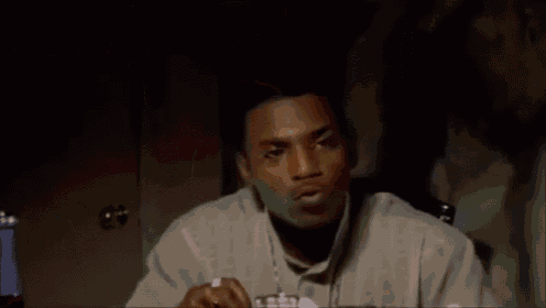 a man is sitting at a table eating food with a fork and spoon .