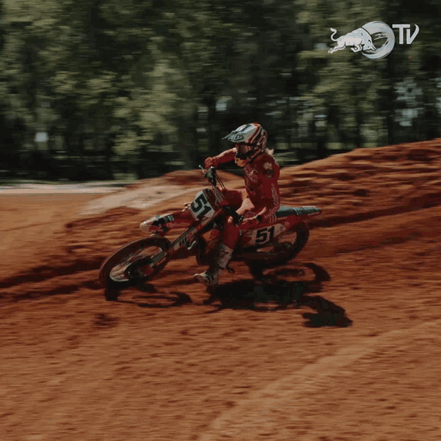 a person is riding a dirt bike with the number 51 on it