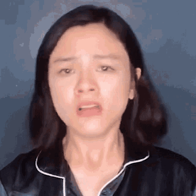 a close up of a woman 's face with a tear running down her face .