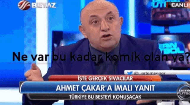 a man in a suit is talking on a tv show with the words ne var bu kadar komik olan ya