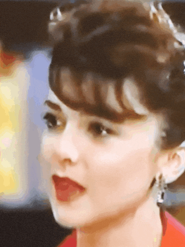 a close up of a woman 's face with a red shirt on