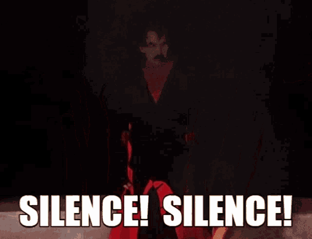 a man in a black suit is surrounded by red hands with the words silence silence written on them