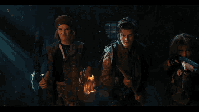 a group of people stand in front of a large fire