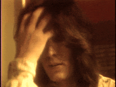 a close up of a person holding their head with their hand