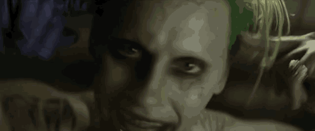 a close up of the face of the joker from the movie suicide squad with green hair .