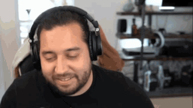a man with a beard wearing headphones is smiling