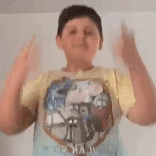 a young boy is making a funny face with his hands while wearing a yellow shirt .