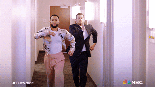 two men are running down a hallway with nbc written on the bottom
