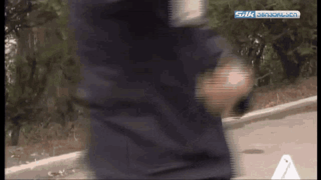 a blurry image of a person walking with silk written on the bottom right