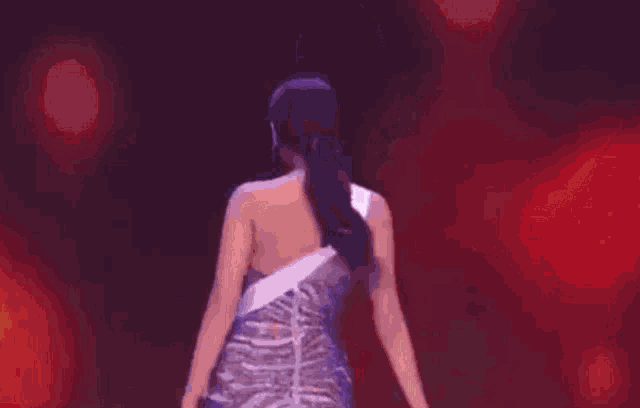 a woman in a blue dress with a sash that says mexico on it is walking on a stage .
