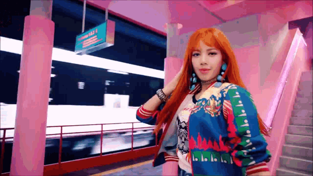 a woman with orange hair is standing in front of a pink building and stairs .
