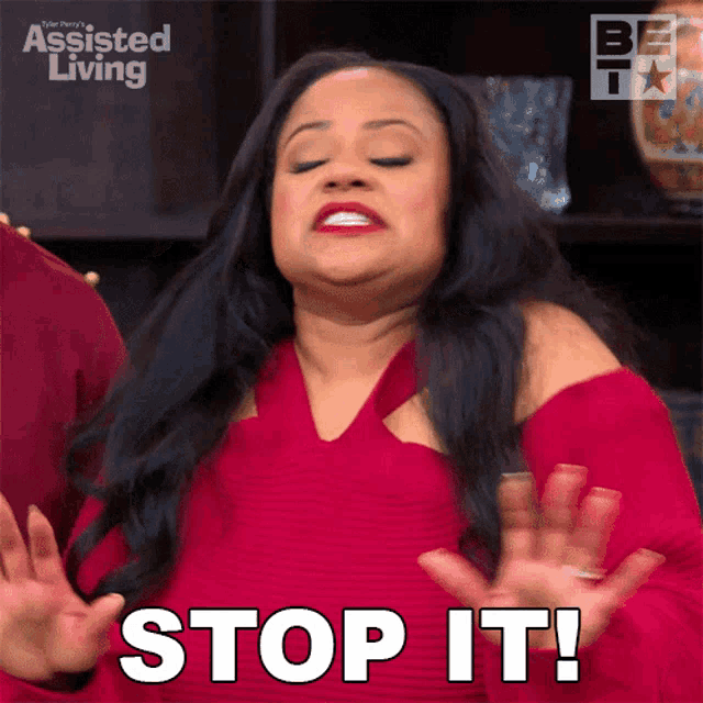 a woman in a red dress says " stop it " with her hands outstretched
