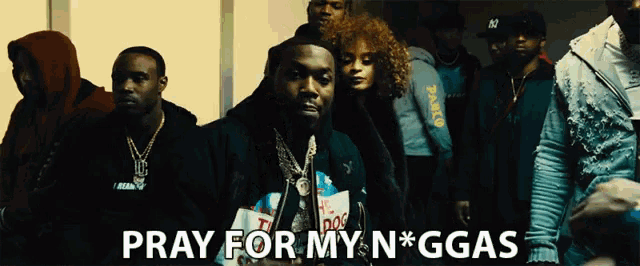 a group of people standing next to each other with the words pray for my n * ggas above them