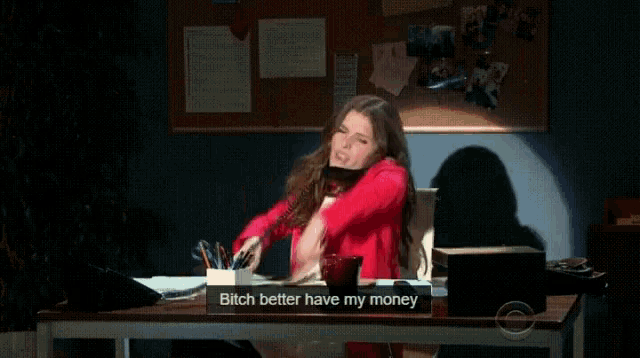 a woman sitting at a desk talking on a phone with a sign that says " bitch better have my money "