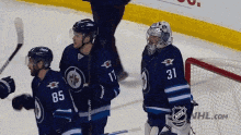 a group of hockey players with one wearing the number 31