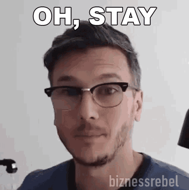 a man wearing glasses and a beard is making a funny face .