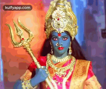 a woman in a costume is holding a trident in her hand .
