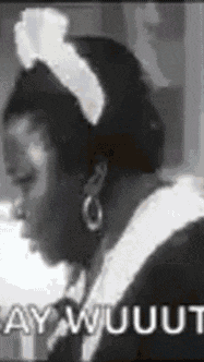 a black and white photo of a woman wearing a maid outfit .