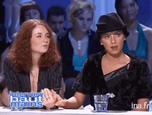 two women are sitting at a table with a glass of water in front of them and the words interview haut mains on the screen