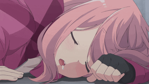 a girl with pink hair is laying down with her tongue out
