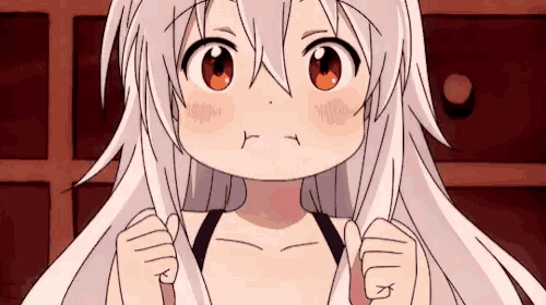 a girl with white hair and red eyes is making a funny face while holding her hair .