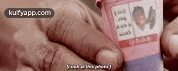 a person is holding a bottle of pills in their hand and saying `` look at this photo '' .