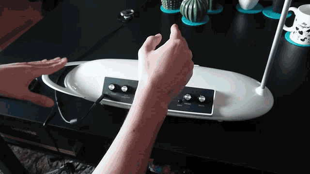 a person 's hand is reaching for a button on a white object