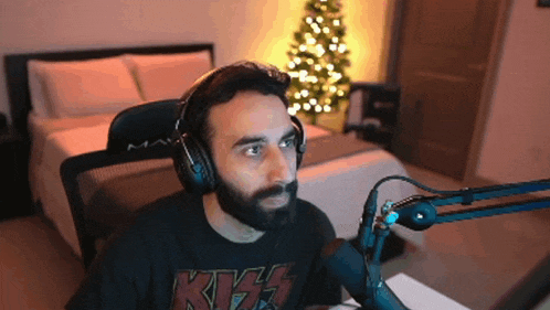 a man with a beard wearing headphones and a kiss shirt