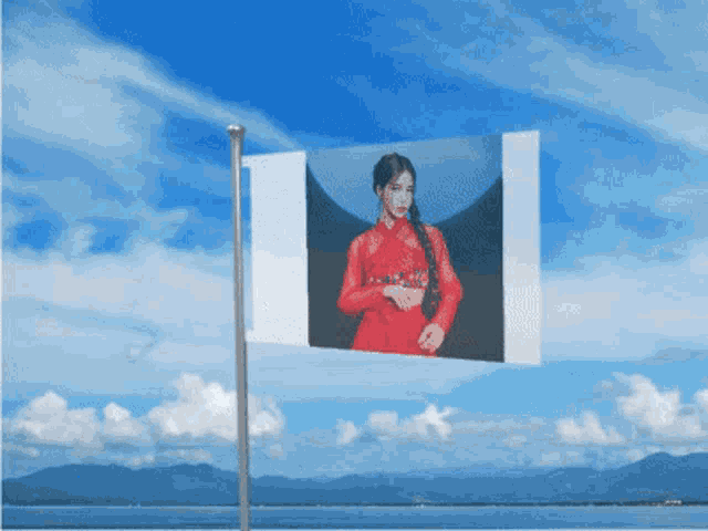 a picture of a woman in a red dress is hanging on a pole